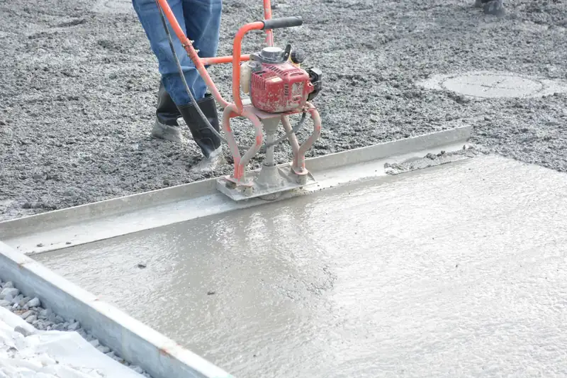 Power screed levelling a fresh concrete surface between forms