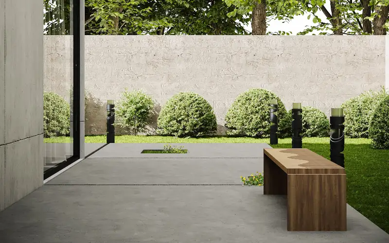 Plain smooth-finish concrete patio with a wood bench beside a lawn