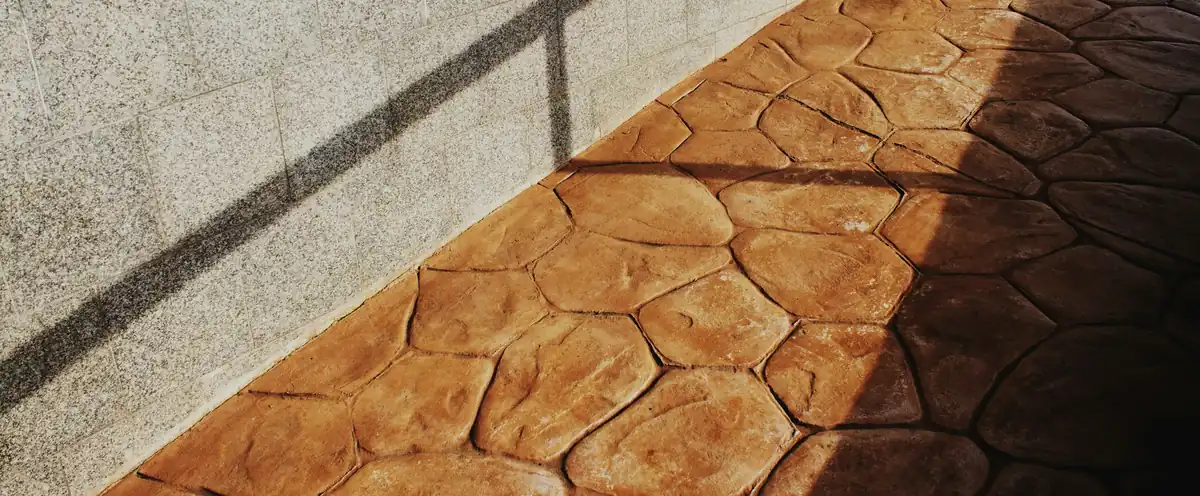 Terracotta-colored stamped concrete walkway in a random flagstone pattern