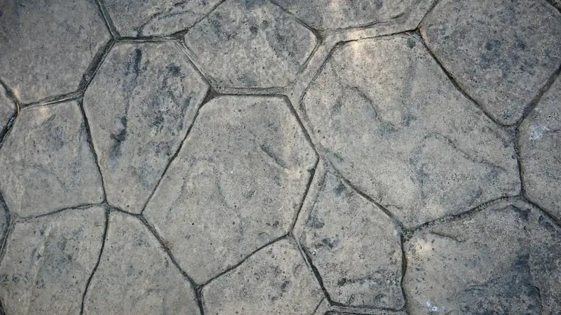 Gray concrete imprinted with a random flagstone pattern and deep joint lines